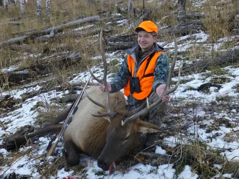 Wyatt Case with a bull elk in the snow